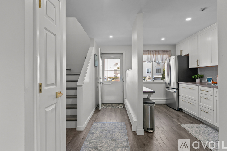 A kitchen with white cabinets and a stainless steel refrigerator.