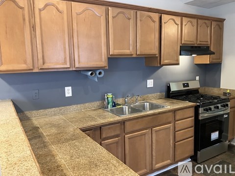 A kitchen with wooden cabinets and a granite countertop.