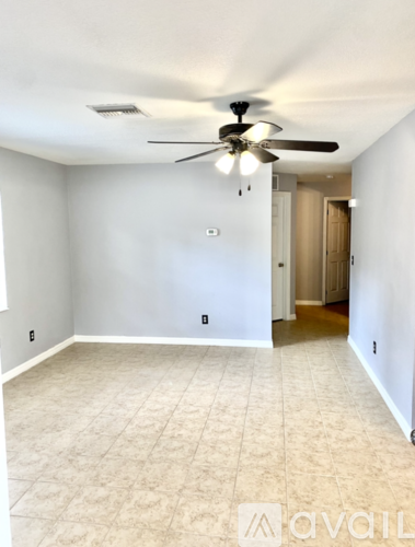A room with a ceiling fan and carpeted floor.