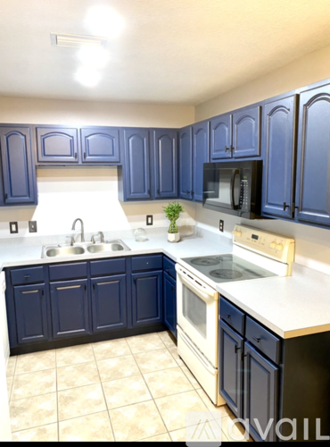 A kitchen with blue cabinets and white countertops.