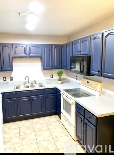 A kitchen with blue cabinets and white countertops.