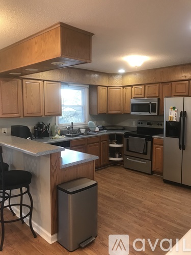 A kitchen with wooden cabinets and a white counter.