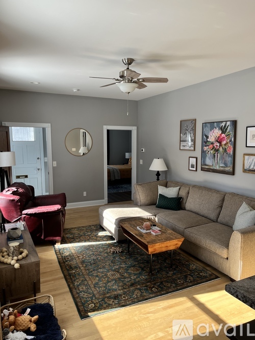 A living room with a couch, a chair, a coffee table, and a rug.