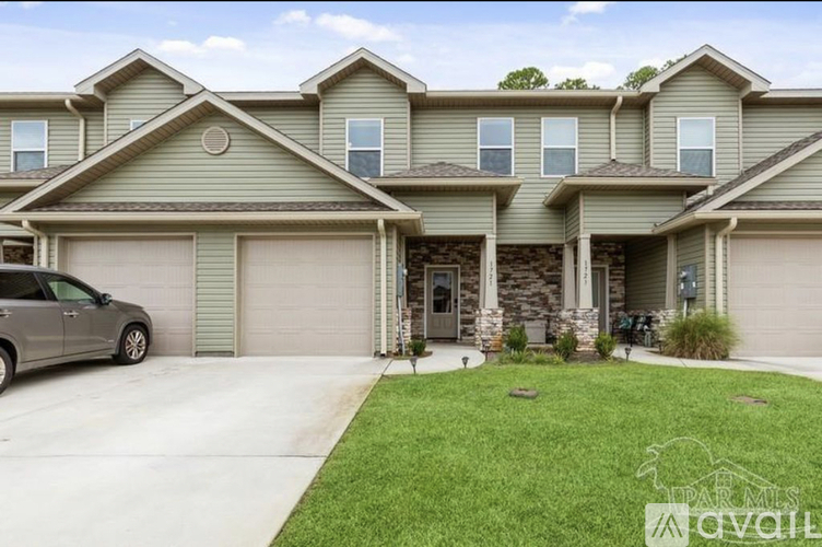 A house with a grey car parked in front.