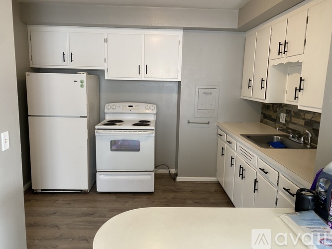 A kitchen with white appliances and cabinets.