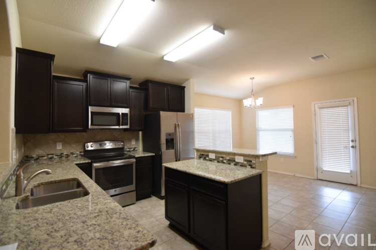 A kitchen with granite countertops and stainless steel appliances.