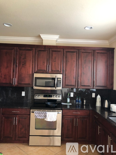 A kitchen with wooden cabinets and a black countertop.