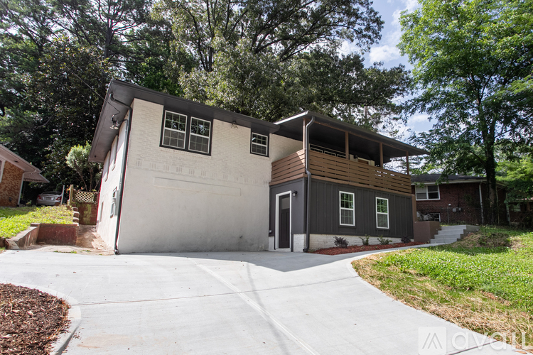 A two-story house with a garage is surrounded by trees.