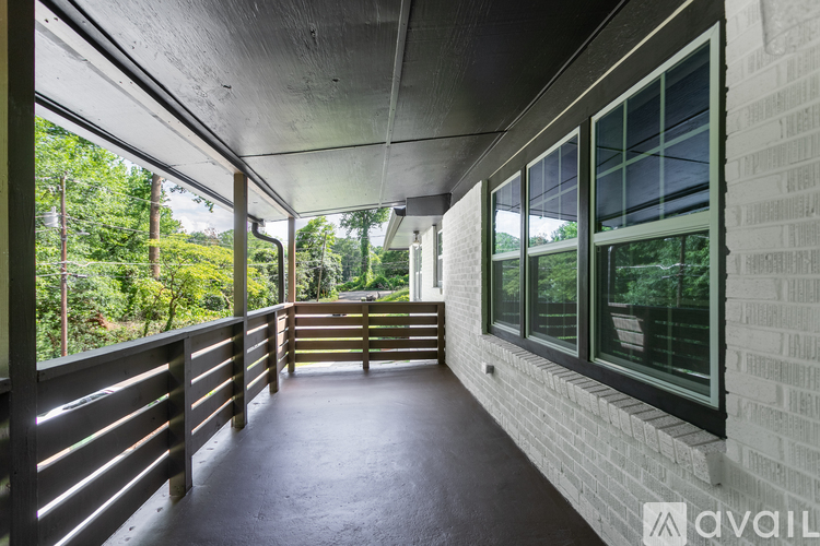 A balcony with a wooden railing and a concrete floor.