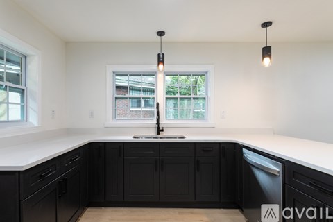 A kitchen with black cabinets and a window.