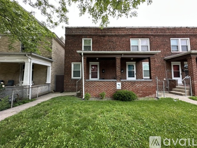 A brick house with a green lawn in front.