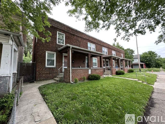 A brick house with a green lawn in front.