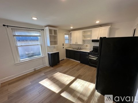 A kitchen with wooden floors and white walls.