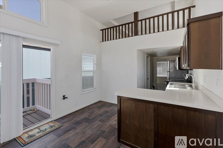 A kitchen with a white counter top and wooden cabinets.