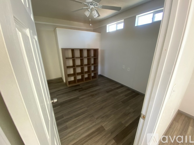 A room with wooden flooring and a ceiling fan.