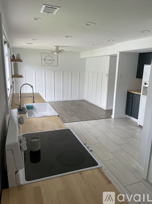 A kitchen with a sink and a fridge.