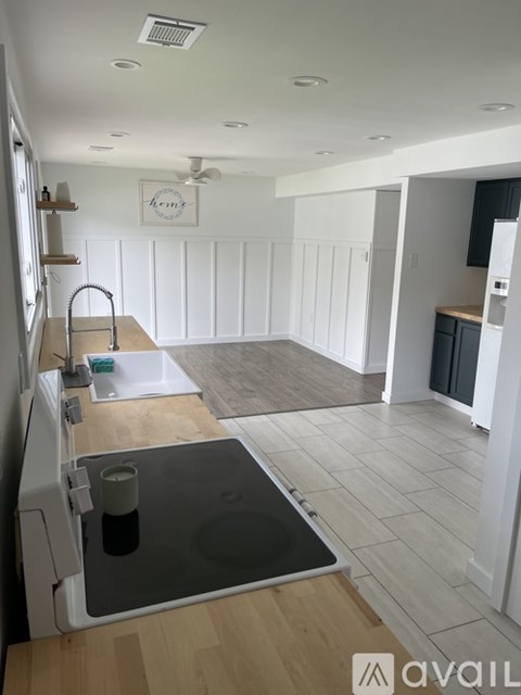 A kitchen with a sink and a fridge.
