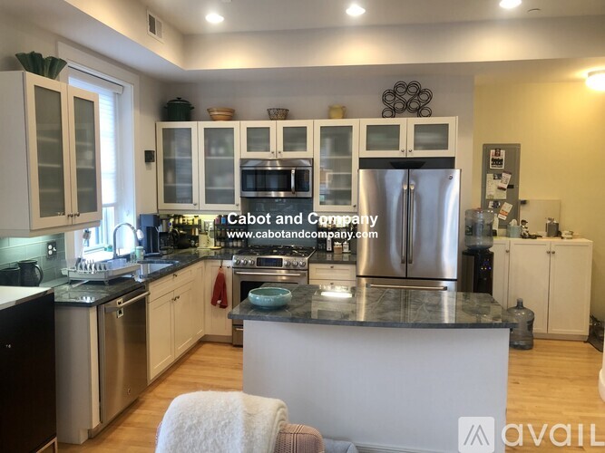 A kitchen with a refrigerator, microwave, and oven.