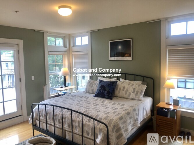 A bedroom with a bed, nightstand, and window.