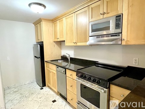 A kitchen with wooden cabinets and black appliances.