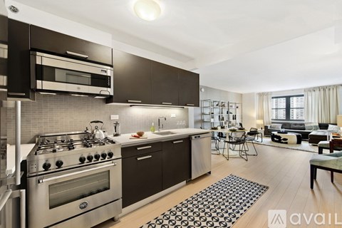 A modern kitchen with dark brown cabinets and stainless steel appliances.