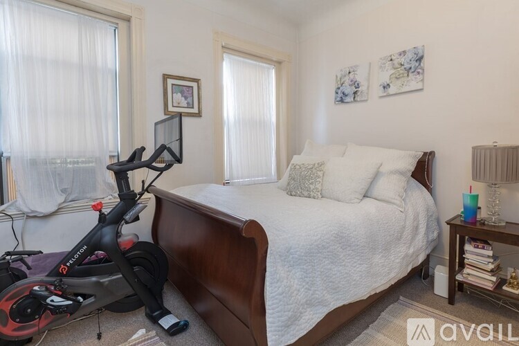 A bedroom with a bed, a bicycle, and a window.