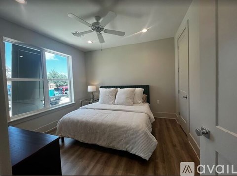 A bedroom with a large bed and a ceiling fan.