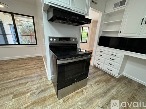A modern kitchen with a stainless steel oven and white cabinets.