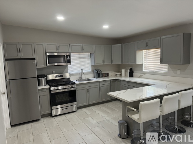 A modern kitchen with stainless steel appliances and a central island.