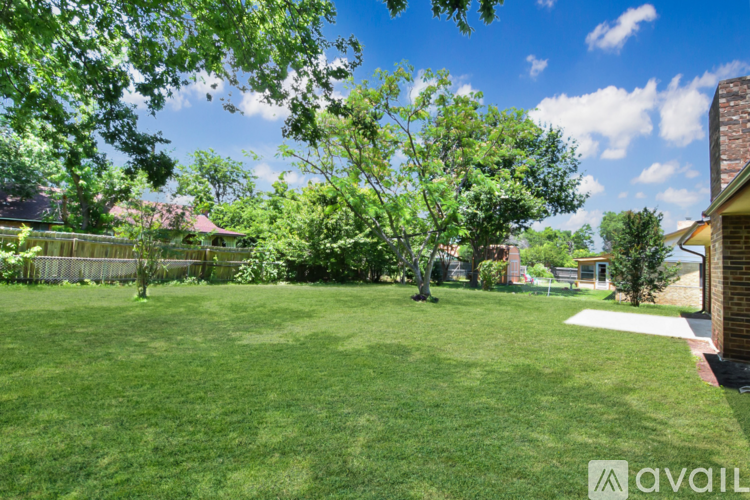 A backyard with a lawn and trees.