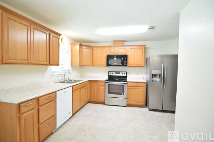 A kitchen with wooden cabinets and a refrigerator.