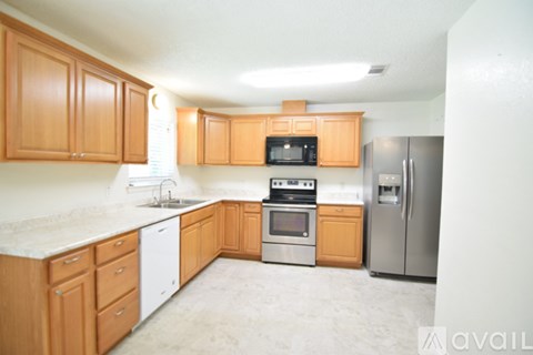 A kitchen with wooden cabinets and a refrigerator.