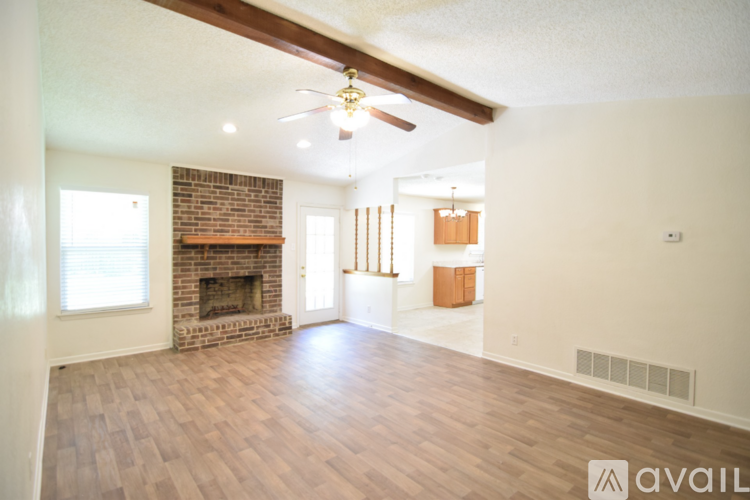A living room with a fireplace and a ceiling fan.