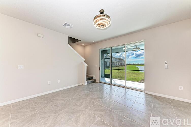 A spacious room with a tiled floor and a staircase leading to another level.