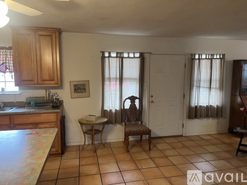 A kitchen with a table and chairs in front of a window.