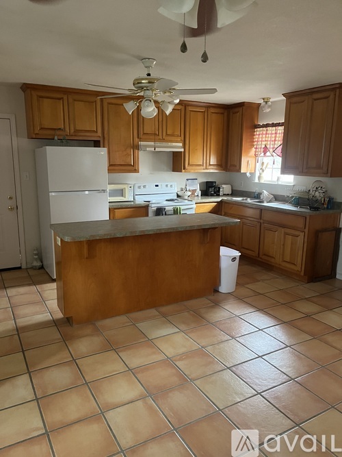 A kitchen with brown cabinets and a white refrigerator.