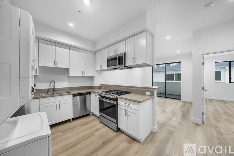 A modern kitchen with white cabinets and appliances.