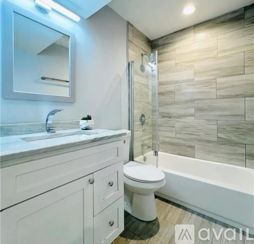 A bathroom with a toilet, sink, and a glass shower door.
