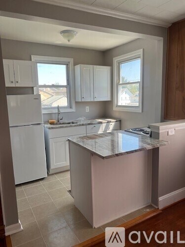A kitchen with white appliances and cabinets.