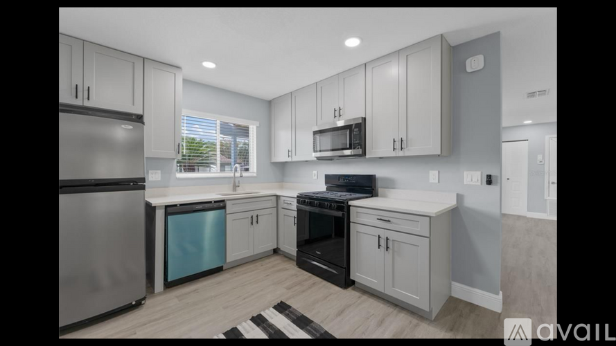 A modern kitchen with stainless steel appliances and white cabinets.