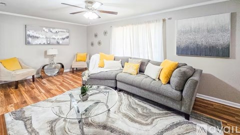 A living room with a grey couch and yellow pillows.