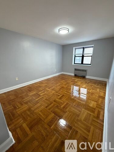 A room with wooden flooring and a window.