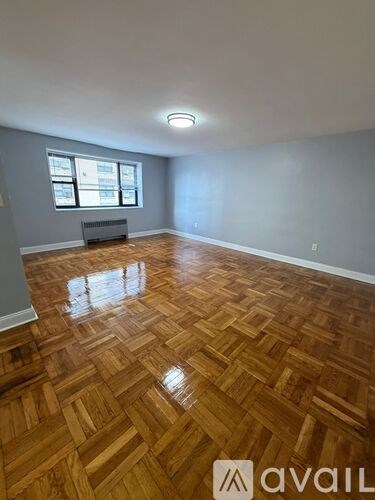 A room with wooden flooring and a window.