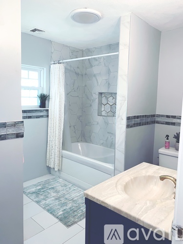 A bathroom with a marble patterned shower curtain.