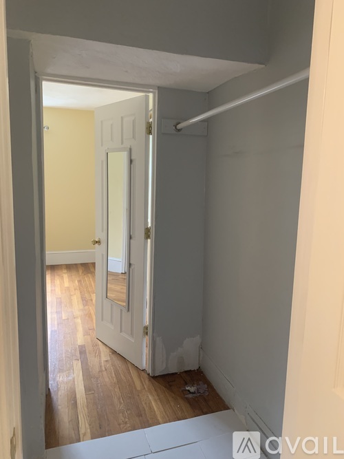 A room with a white door and a wooden floor.