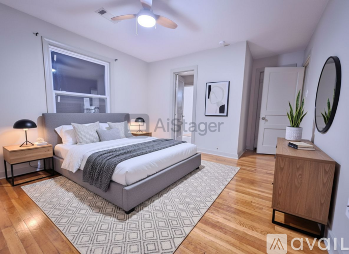 A well-lit bedroom with a large bed and a wooden floor.