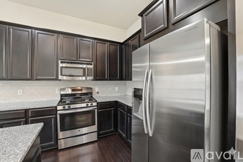 A kitchen with a stainless steel refrigerator and oven.