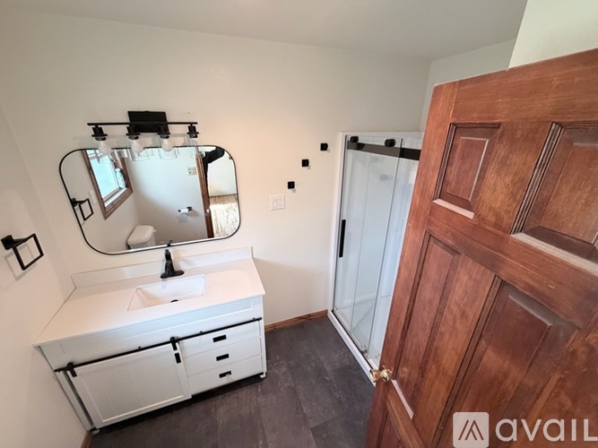 A bathroom with a white sink and a mirror above it.