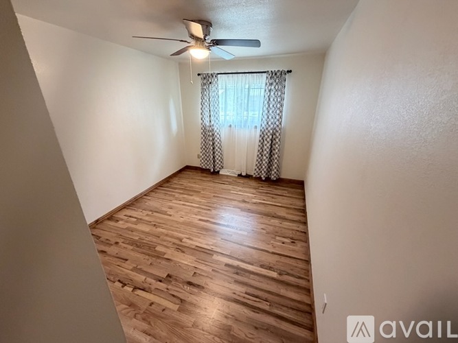 A room with wooden flooring and a ceiling fan.