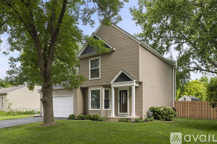 A house with a brown roof and a tree in front of it.
